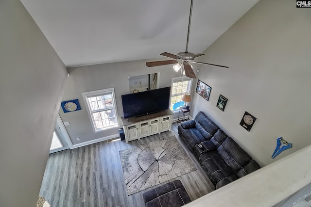 living room featuring ceiling fan, wood-type flooring, and lofted ceiling