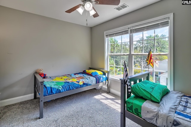 bedroom featuring multiple windows, ceiling fan, and carpet floors