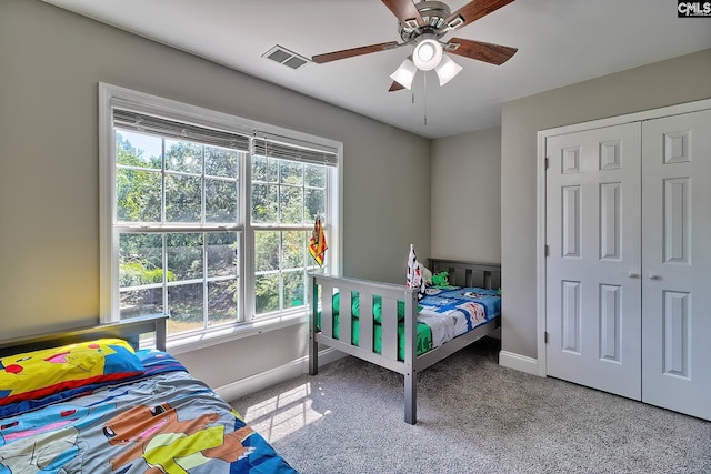 bedroom with light carpet, multiple windows, a closet, and ceiling fan