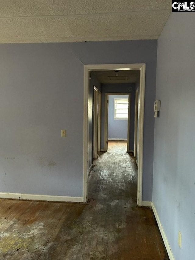 hall with a textured ceiling and dark hardwood / wood-style floors