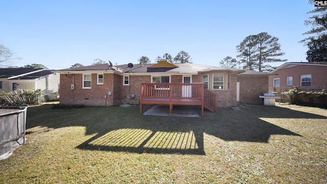 rear view of property with a lawn and a wooden deck