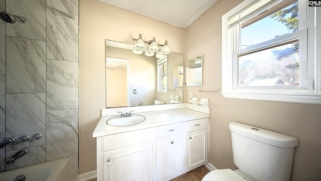 full bathroom featuring vanity, a textured ceiling, toilet, and tiled shower / bath