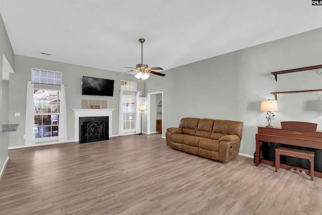 living room featuring ceiling fan and light hardwood / wood-style floors