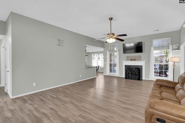 unfurnished living room featuring light wood-type flooring and ceiling fan