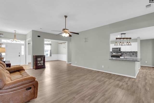 living room with light hardwood / wood-style floors, ceiling fan, and sink