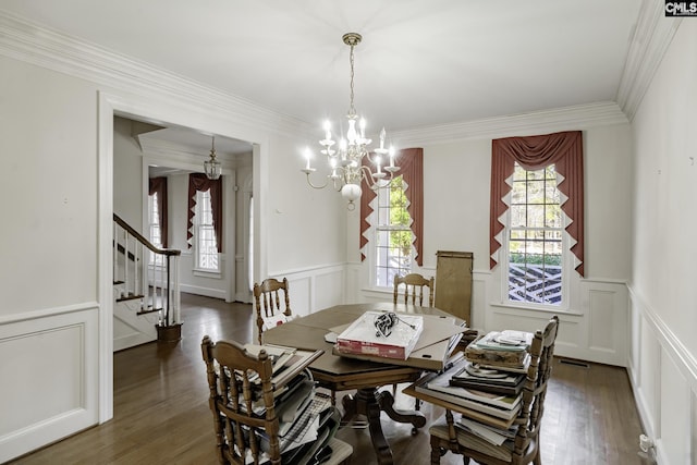 dining space with dark hardwood / wood-style floors, crown molding, and a chandelier