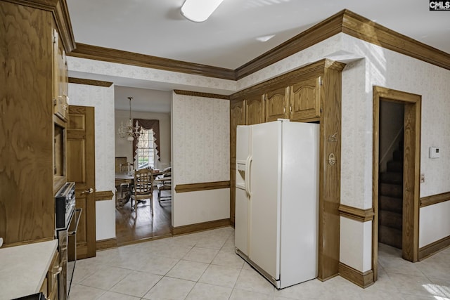 kitchen with white fridge with ice dispenser, an inviting chandelier, crown molding, decorative light fixtures, and light tile patterned floors