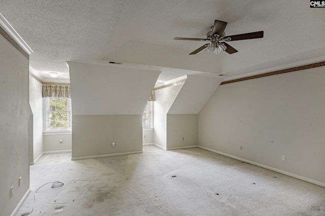 additional living space with ceiling fan, lofted ceiling, a textured ceiling, and light carpet