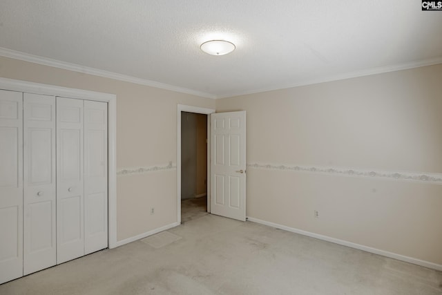 unfurnished bedroom with light carpet, a closet, crown molding, and a textured ceiling