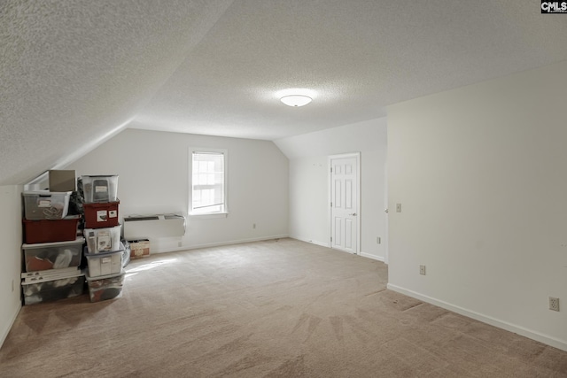 additional living space featuring carpet, lofted ceiling, and a textured ceiling