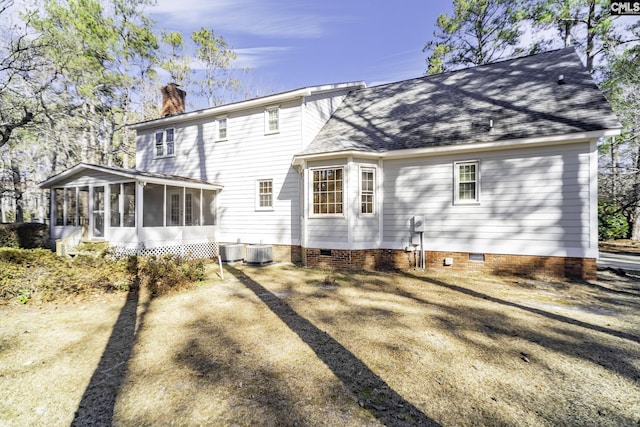 back of property with a sunroom and central AC