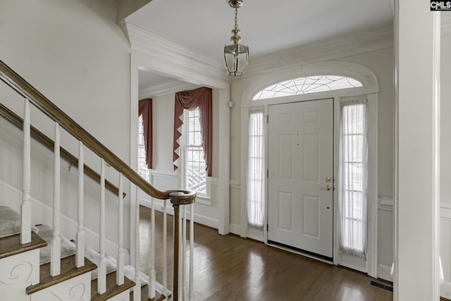 entryway with plenty of natural light, crown molding, and dark wood-type flooring