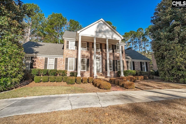 greek revival inspired property featuring a front yard