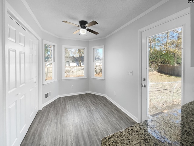 foyer with ceiling fan, dark hardwood / wood-style flooring, a textured ceiling, and ornamental molding