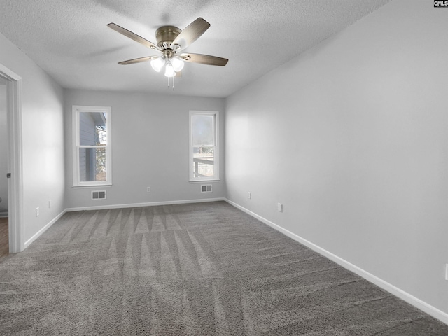 carpeted empty room with ceiling fan and a textured ceiling