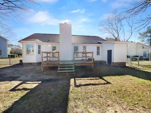 rear view of house with a yard and a wooden deck