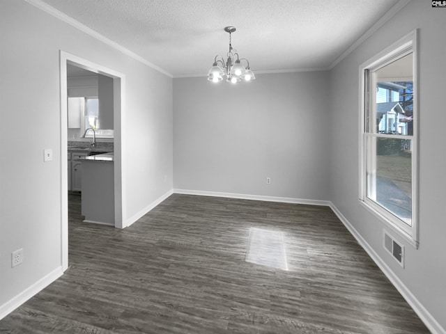 unfurnished dining area with sink, an inviting chandelier, dark hardwood / wood-style floors, a textured ceiling, and ornamental molding