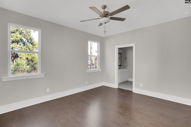 empty room with dark wood-type flooring, ceiling fan, and a healthy amount of sunlight