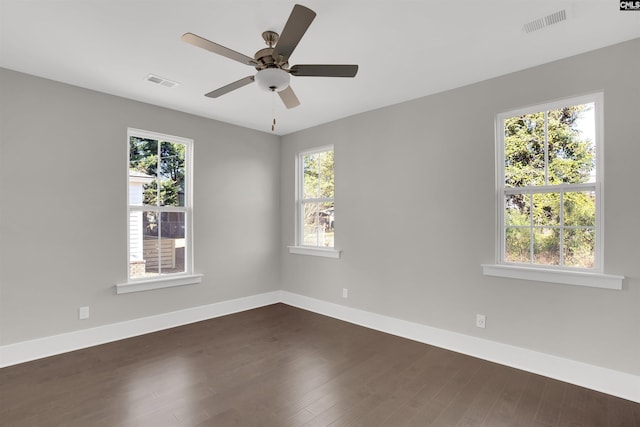 unfurnished room with dark wood-type flooring, ceiling fan, and a healthy amount of sunlight