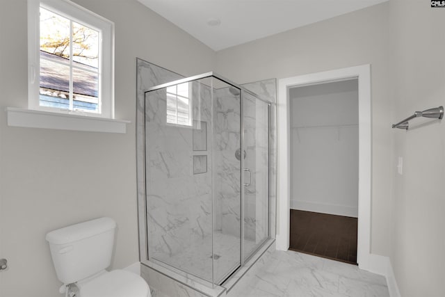 bathroom featuring toilet and a shower with shower door