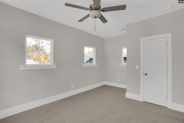 carpeted spare room featuring ceiling fan