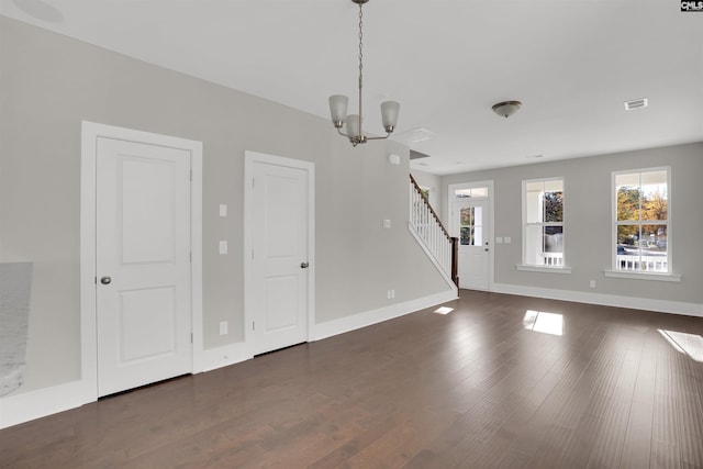 interior space featuring dark wood-type flooring and an inviting chandelier