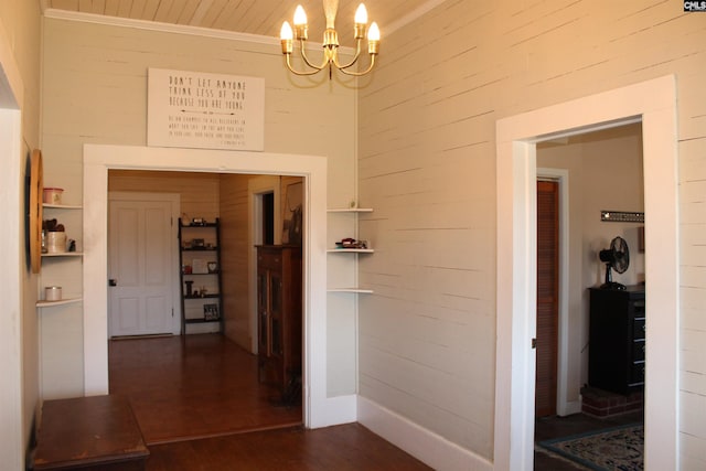 hall with a notable chandelier, dark hardwood / wood-style floors, wood ceiling, and wooden walls