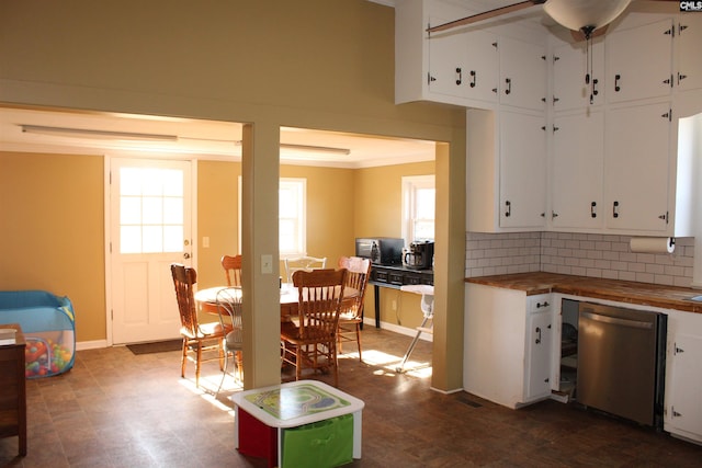 kitchen featuring white cabinets, stainless steel dishwasher, tasteful backsplash, and wooden counters