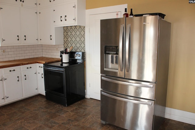 kitchen featuring wooden counters, white cabinets, black range with electric stovetop, stainless steel fridge, and tasteful backsplash