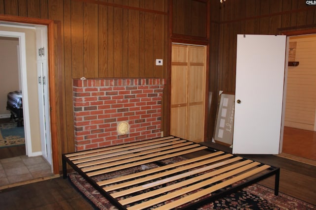 interior space with dark wood-type flooring, a closet, and wooden walls