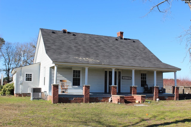 view of front of property with covered porch, central air condition unit, and a front lawn