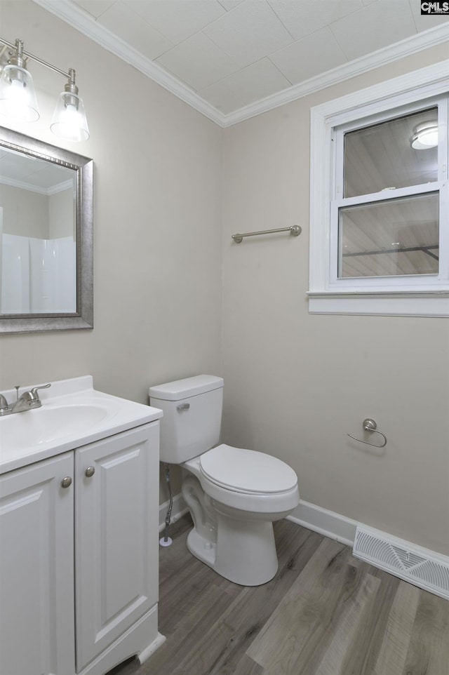 bathroom featuring toilet, hardwood / wood-style floors, vanity, and ornamental molding