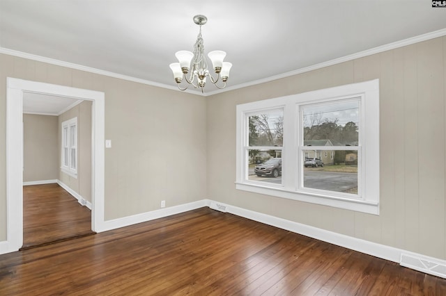 empty room featuring crown molding, a chandelier, and hardwood / wood-style flooring