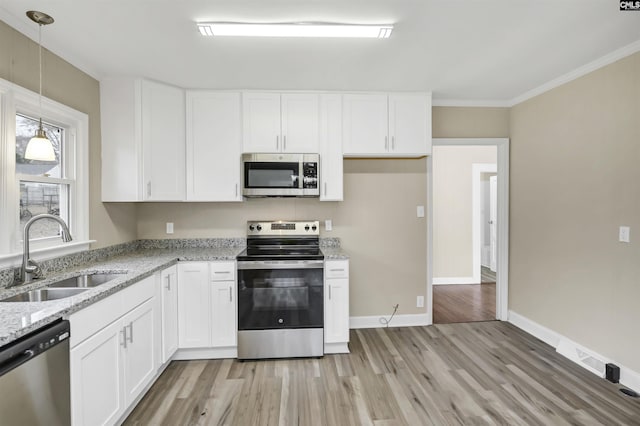 kitchen featuring light stone countertops, white cabinetry, sink, pendant lighting, and appliances with stainless steel finishes