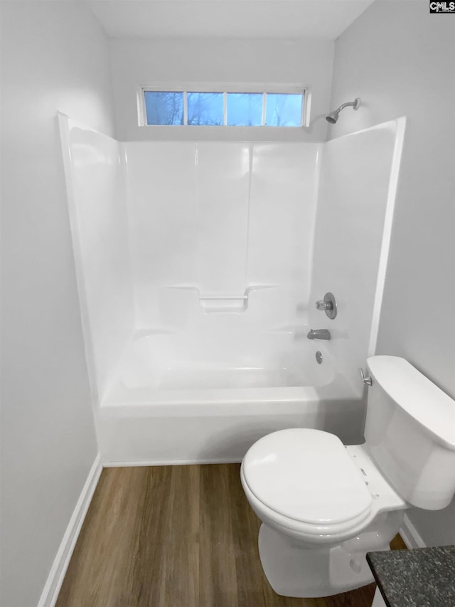 bathroom with toilet, wood-type flooring, and shower / tub combination