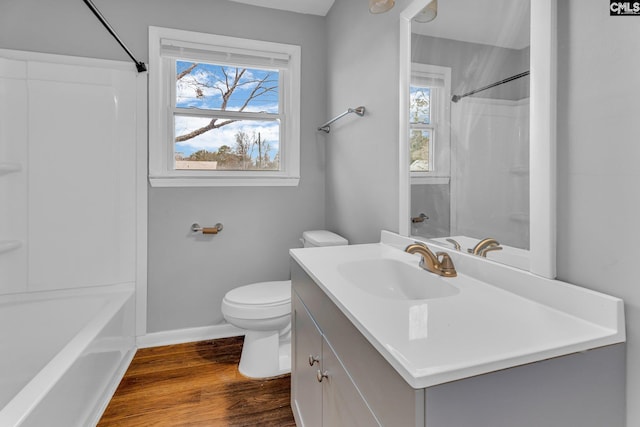 full bathroom with hardwood / wood-style floors, vanity, bathing tub / shower combination, and toilet