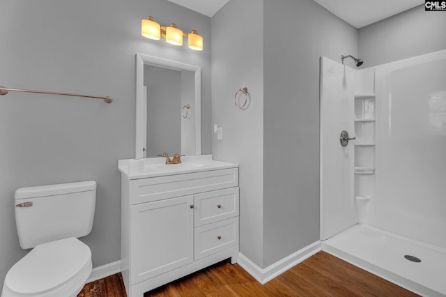 bathroom with hardwood / wood-style flooring, vanity, toilet, and a shower