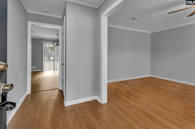 hall with crown molding, light hardwood / wood-style flooring, and a notable chandelier