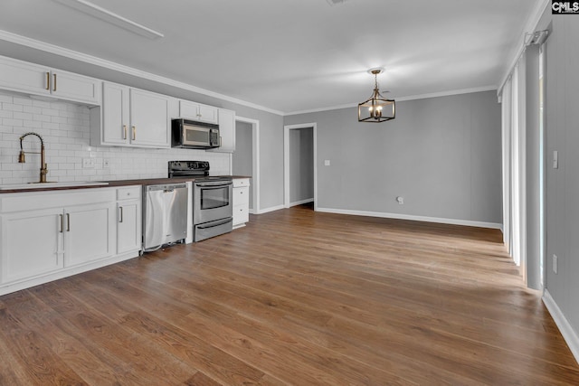 kitchen with sink, stainless steel appliances, wooden counters, decorative backsplash, and white cabinets