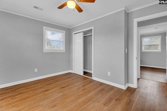 unfurnished bedroom featuring a closet, ceiling fan, light hardwood / wood-style flooring, and crown molding