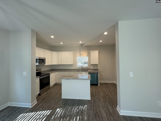 kitchen featuring white cabinetry, sink, light stone counters, a kitchen island, and appliances with stainless steel finishes