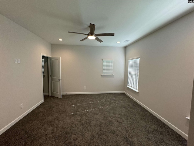 unfurnished room featuring dark carpet and ceiling fan