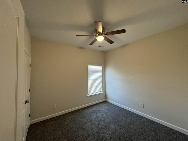 empty room with dark colored carpet and ceiling fan