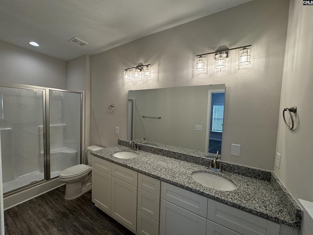 bathroom featuring hardwood / wood-style flooring, vanity, toilet, and an enclosed shower