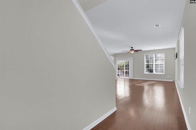 interior space with hardwood / wood-style flooring, ceiling fan, and ornamental molding