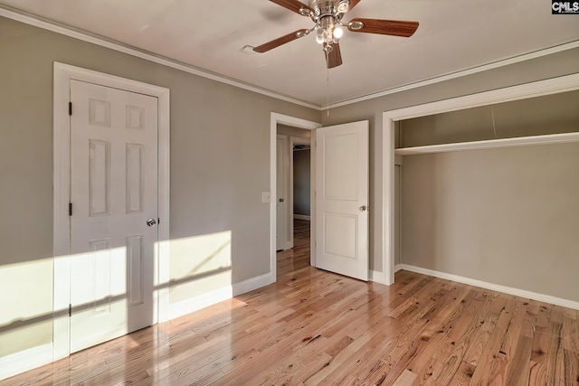 unfurnished bedroom featuring ceiling fan, light wood-type flooring, ornamental molding, and a closet