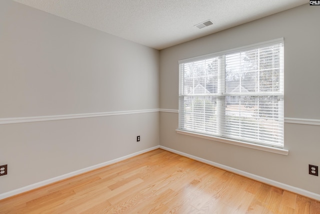 empty room with a textured ceiling and hardwood / wood-style flooring