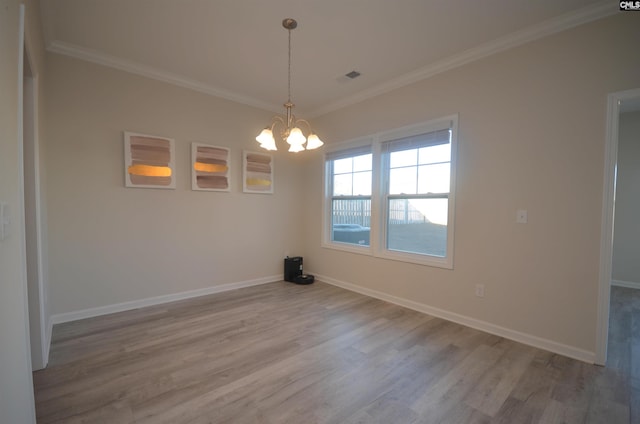 unfurnished dining area featuring crown molding, a chandelier, and hardwood / wood-style flooring