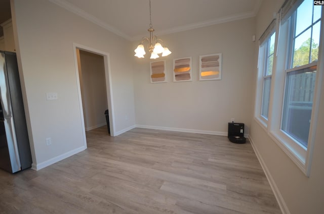 unfurnished dining area with crown molding, a chandelier, and light wood-type flooring