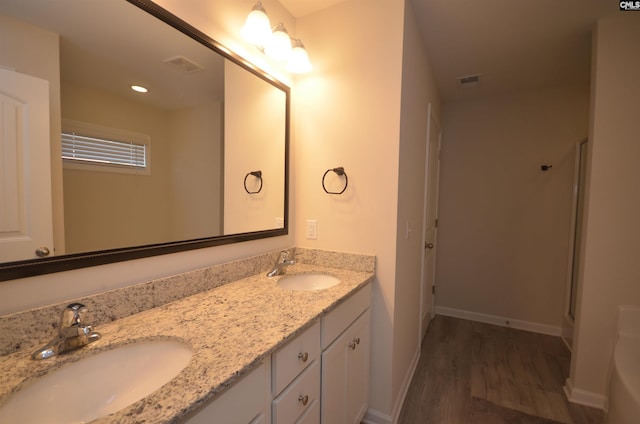 bathroom with vanity, an enclosed shower, and hardwood / wood-style flooring